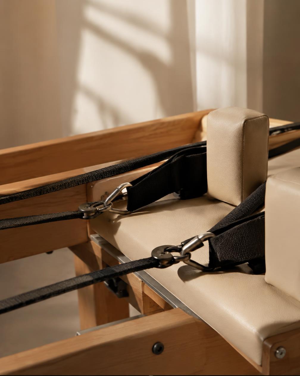 Close detail of reformer springs and straps in a calm studio